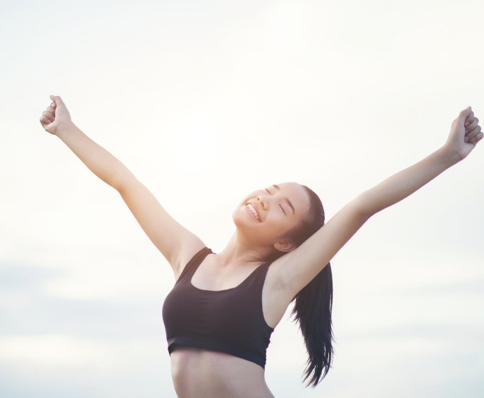 Happy smiling athletic woman with arms outstretched