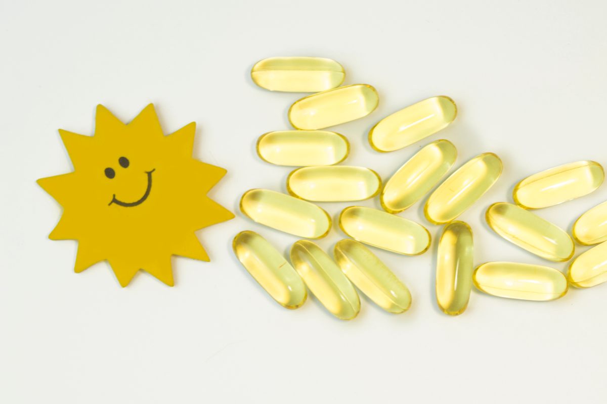Vitamin D capsules with a sun drawing to explain the sun vitamin concept